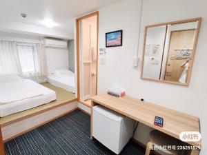 大阪da inn的客房设有一张床、一张书桌和一面镜子