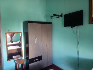 Cruzeiro do OesteHotel da Gaucha的卧室配有镜子和墙上的电视