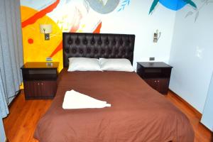 库斯科Magic Packer Hostel的一间卧室配有一张带2个床头柜的大床
