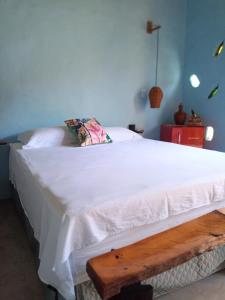 哥隆巴奥Odoyá Corumbau的卧室配有白色的床和木凳