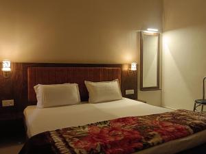 瓦拉纳西Happy Homes的卧室配有一张带白色床单和枕头的大床。