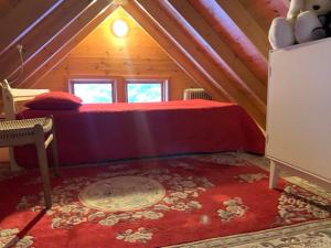 惠拉盖尔济Beautiful Cottage in Hveragerdi的阁楼卧室配有红色床