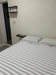 累西腓Excelentes Quartos com banheiros privativos的一间卧室配有带条纹被子的床