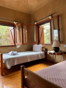 Kato AmiandosKardama HideAway的一间卧室设有两张床和两个窗户。