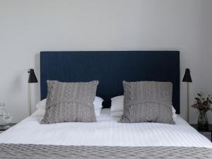 都柏林彭布罗克浩尔旅馆的一张带蓝色床头板和枕头的大床