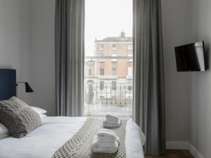都柏林彭布罗克浩尔旅馆的一间卧室设有一张床和一个大窗户