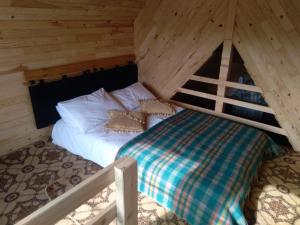 Sultan Murat Yaylasi比尔利克亚伊拉肯特度假屋的小木屋内的一张床位,配有四柱床