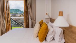 卡塔赫纳Del Mar Guest House的一间卧室配有一张带黄色枕头的床和一扇窗户