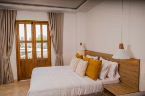 卡塔赫纳Del Mar Guest House的一间卧室配有白色床和黄色枕头