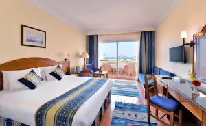 考拉亚湾Bliss Nada Beach Resort的配有一张床和一张书桌的酒店客房