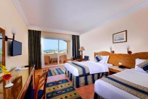 考拉亚湾Bliss Nada Beach Resort的酒店客房设有两张床和窗户。