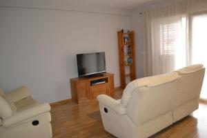 Vivienda Falda del Monsacro的客厅配有2把椅子和平面电视