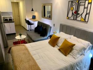 波哥大Apartaestudio súper ubicado的一间卧室配有一张带两个黄色枕头的床