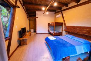 圣加布里埃尔Recanto Ecológico的一间卧室配有一张床、一张书桌和一台电视