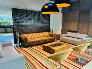巴西利亚娜鸿酒店的客厅配有棕色真皮沙发和椅子