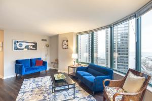 芝加哥Captivating Apartment with Pier Views, Pool and Gym的客厅设有蓝色家具和大窗户