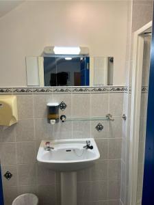 丁格尔Coastguard Lodge Hostel at Tigh TP的一间带水槽和镜子的浴室