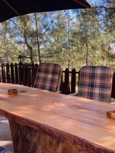 Kato AmiandosKardama HideAway的木桌旁的两把椅子和木头