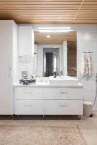 坦佩雷Top, cozy, lakeside, sauna and free indoor parking的白色的厨房配有水槽和镜子