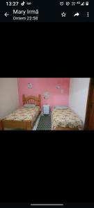 阿拉鲁阿马Suite familiar的配有粉红色墙壁的客房内的两张床