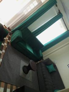 KisiiEagles one bedroom in Kisii CBD with Balcony的一间卧室设有一张绿色的床和一个窗户。