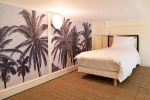 里昂Suite Amalfi的一间卧室配有棕榈树壁画床