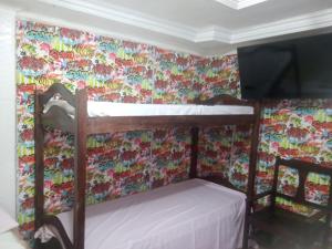 萨尔瓦多Casa Da Lucia的配有花卉壁纸的客房内的双层床