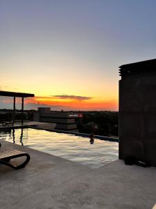 亚松森Departamento 1 habitación zona exclusiva的一座享有日落美景的建筑的顶部游泳池