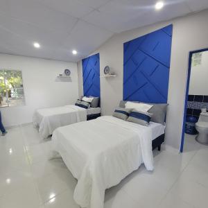 拉利伯塔德RANCHO SARIMAR的一间卧室设有两张床和蓝色的墙壁