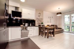科沃布热格Apartament z Ogródkiem - Alldayholiday的厨房以及带桌子和沙发的客厅。