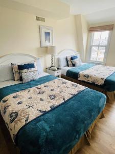 Bay Head格林维尔宾馆及餐厅的一间卧室配有两张带蓝色棉被的床