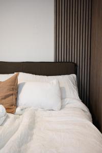 特隆赫姆Hotel feeling in the center of Trondheim的一张带白色床单和棕色枕头的床