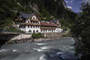 迈尔霍芬Hostel Chillertal的山旁的河边的建筑物