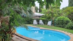 宛图里那Casa del Sole的一个带两把白色椅子的庭院内的游泳池