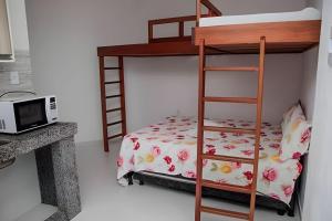 凯鲁Flats Nascer do Sol的一间卧室配有双层床和微波炉