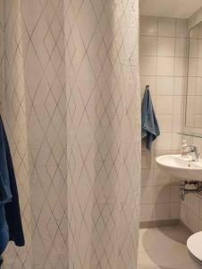 RødovreLille nest的浴室配有淋浴帘和盥洗盆。