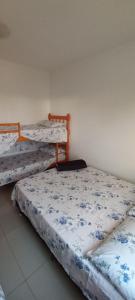 圣加布里埃尔Vanessa pousada familiar的一间设有三张床的客房,配有蓝色和白色的床单