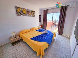 圣地亚哥港7Lizards - Ocean View Apartments的一间卧室配有一张带蓝色毯子的大床