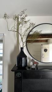 法尔肯堡B&B No. 42的一张黑色花瓶,坐在一张桌子上,带镜子