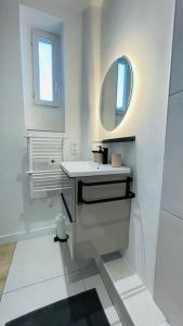 维勒班Appartement rénové proche du parc de la tête d'or的白色的浴室设有水槽和镜子
