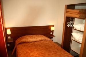 普隆比埃莱班布兰奇住宿酒店的一间卧室配有一张带橙色毯子的床
