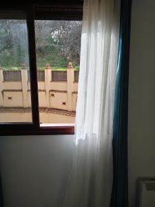 莫纳奇尔Rincón de María José的窗户配有白色窗帘,享有美景