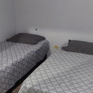 伊瓜苏Studio Iguassu falls GARAGEM COZINHA E AR的两张睡床彼此相邻,位于一个房间里