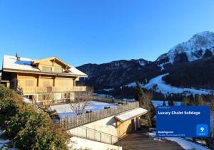 RougemontLuxury Chalet Solidage的大房子,有雪覆盖的山