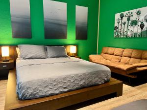 Lake AlfredThe Tatman Evergreen Suite的一间卧室设有绿色的墙壁、一张床和一张沙发