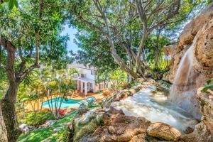 檀香山Villa Ahina的一座带瀑布和游泳池的房子