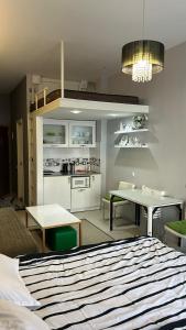 古多里White Tiger in New Gudauri II的一间卧室配有一张床铺和一张桌子,还设有一间厨房