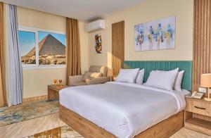 开罗Soul Pyramids View的酒店客房设有一张大床,享有金字塔的景色。