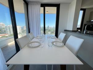 埃斯特角城View Luxury的白色桌子、白色椅子和玻璃杯