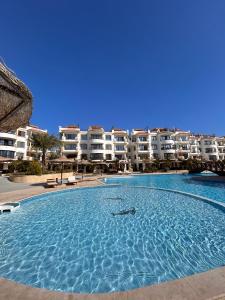 沙姆沙伊赫Studio on the ground floor in Sharm Hills Resort with private garden and pool view的一座大型游泳池,位于部分公寓大楼前